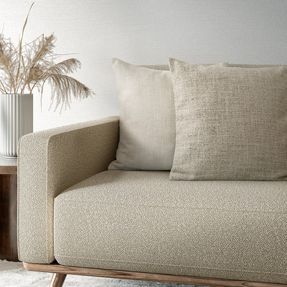Beige sofa with textured cushions in a minimalistic living room setting.
