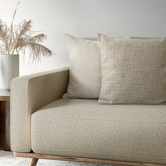Beige sofa with textured cushions in a minimalistic living room setting.