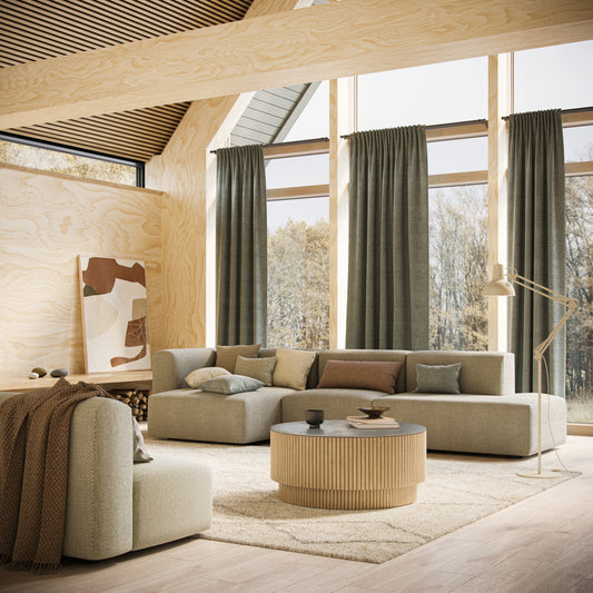 Modern living room with wooden floor, beige sofa, and large windows.